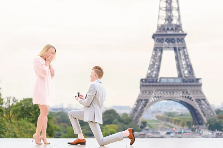 Hero image for Best Places to Propose in Paris: a couple on the Trocadéro platform at sunrise as he kneels to propose with the Eiffel Tower in the background